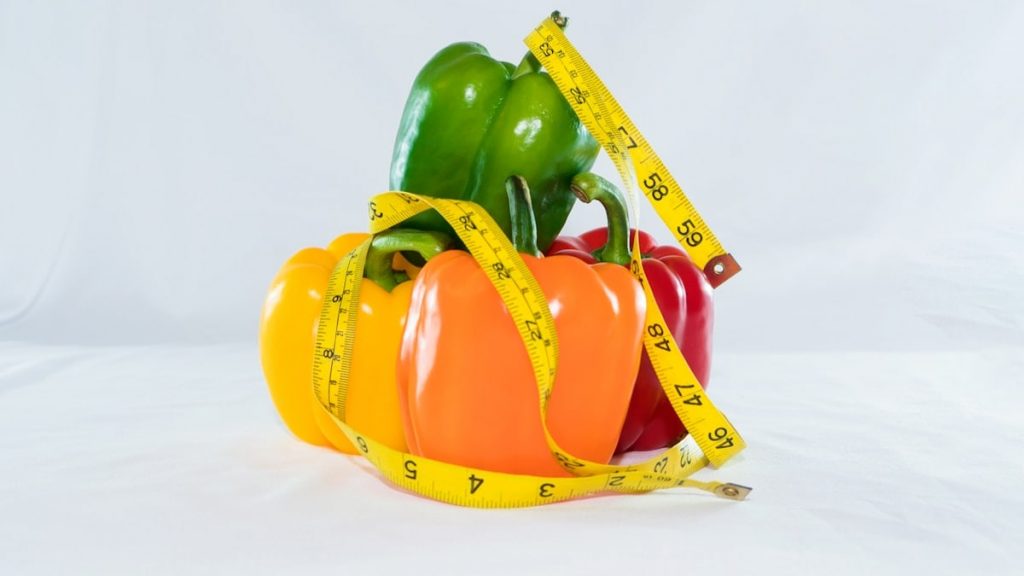 a measuring tape wrapped around peppers and peppers