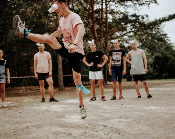 A group of people enjoying an outdoor game with fun eye covers and energetic movements.